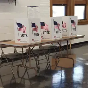 A row of voting booths on a table.