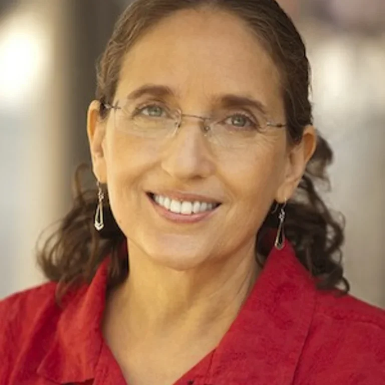 Headshot of Ruth Defries wearing red shirt.