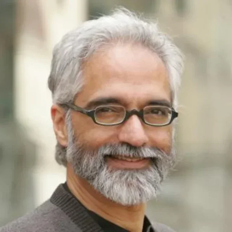 Headshot of Shahid Naeem wearing glasses and smiling at the camera.
