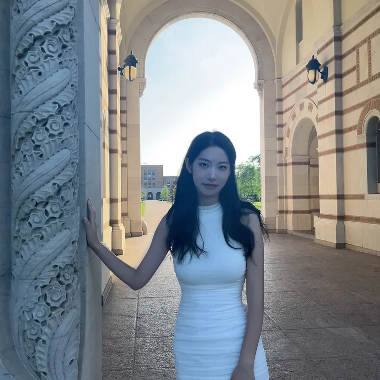 Zuoqing (Lenita) Lyu smiling in a white dress standing under an archway