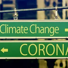 Green street signs displaying the word "Climate Change" with a right arrow and "CORONA" with a left arrow