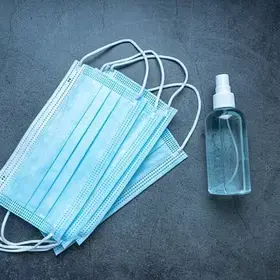 three face masks and a small unbranded spray bottle of sanitizer