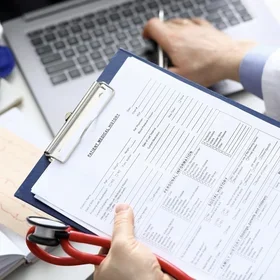 medical paperwork and laptop