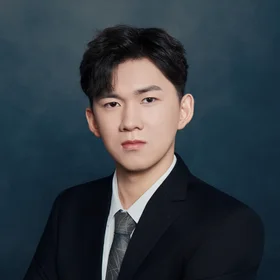 professional headshot of Joe Wang wearing black suit, white dress shirt, and grey tie