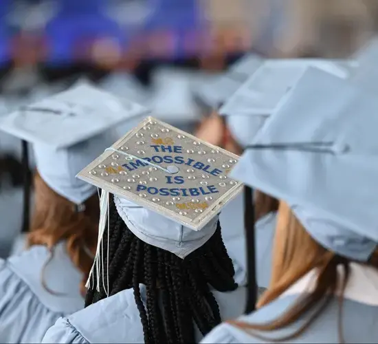 A graduation cap reads "The Impossible Is Possible."