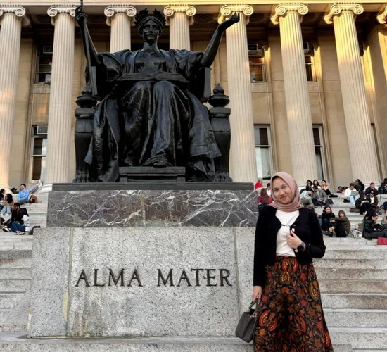 Alma Madina in front of the Alma Mater statue on campus