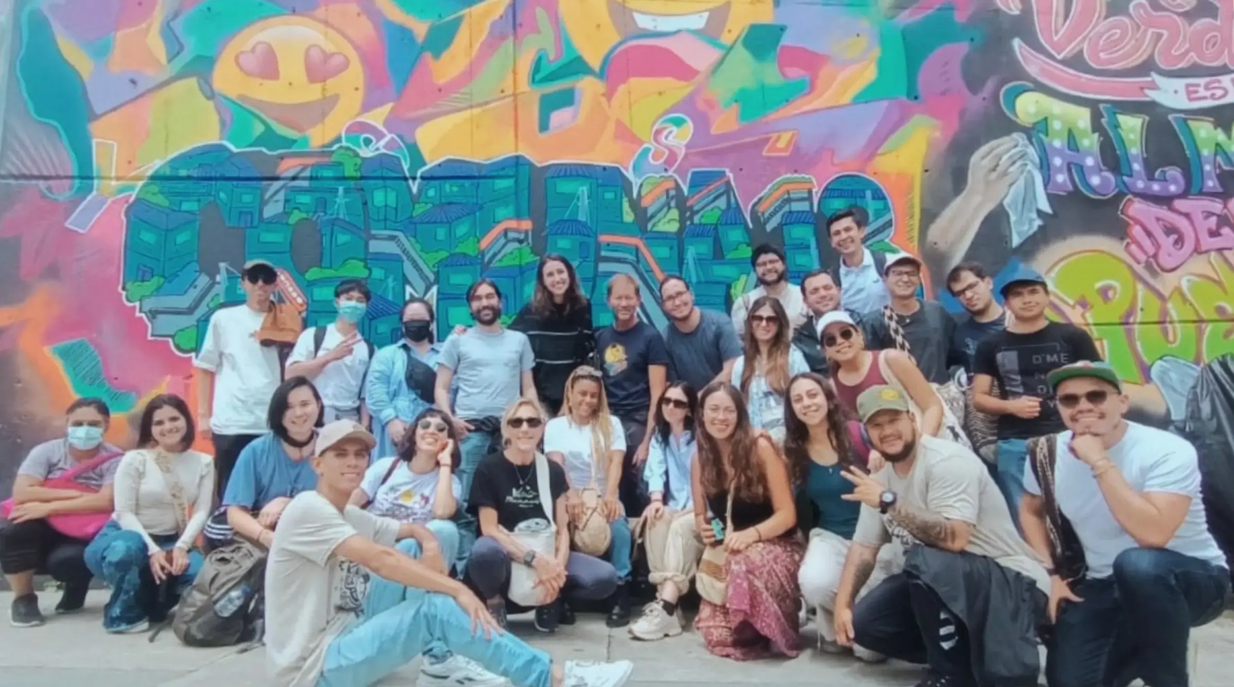 Group photo in front of graffiti mural