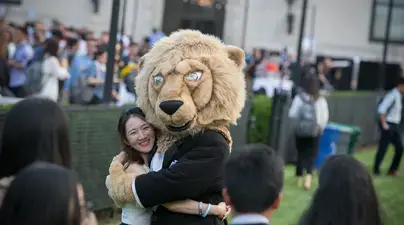 A student hugs the Columbia mascot Roar-ee the lion.