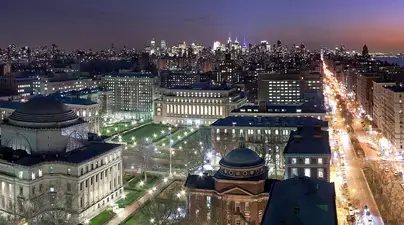 A view of Columbia's campus at night, with the city visible