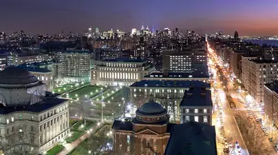 A view of Columbia's campus at night, with the city visible
