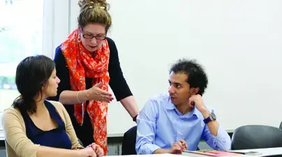 Teacher interacting with two students in class