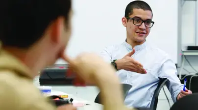 A student talks as his classmate listens