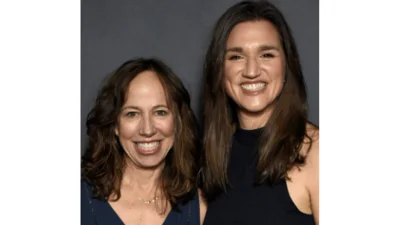 smiling caucasian women with long brown hair in dark sleeveless blouses